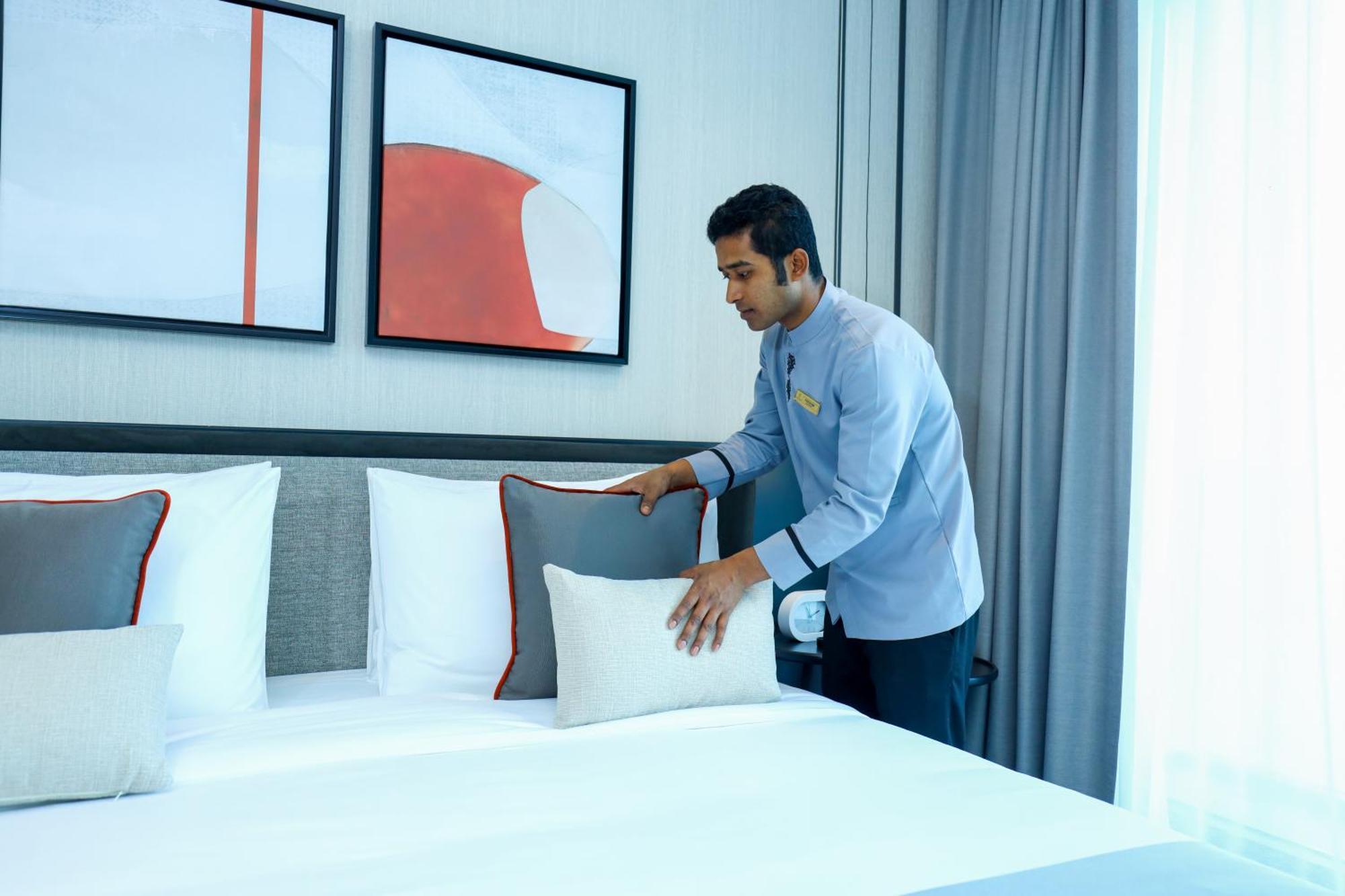 Hotel Charthouse Bahrain Al Manamah Esterno foto A hotel housekeeper making a bed